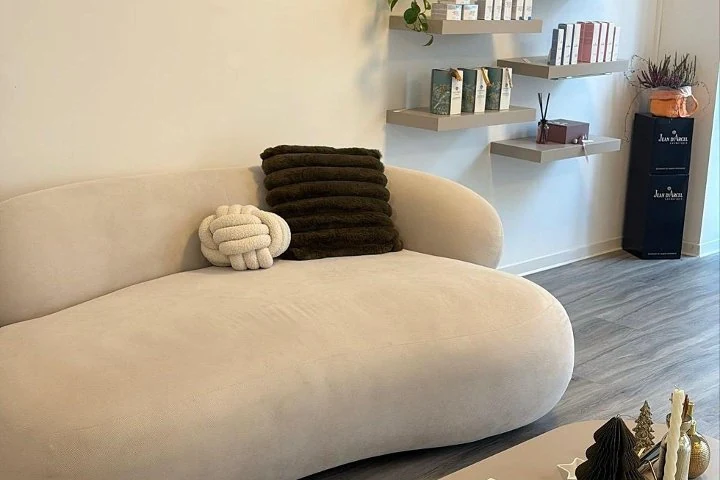 Helle Beauty-Lounge mit geschwungenem Sofa und Produktregal
